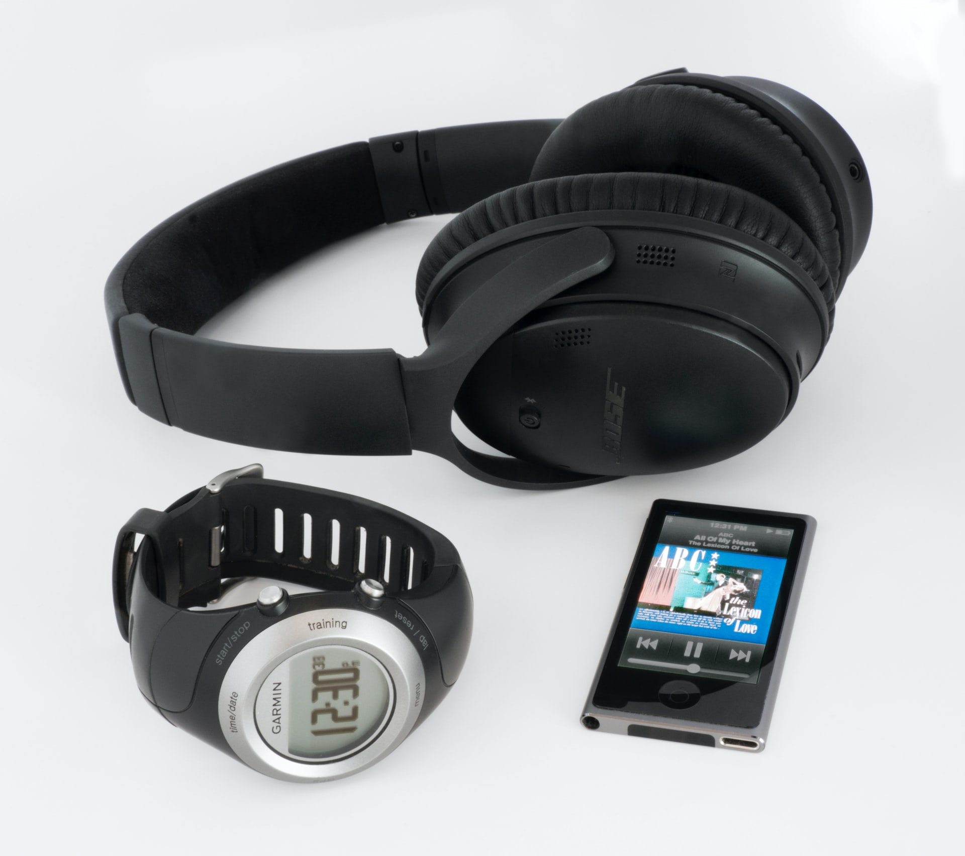 black Bose wireless headphones near smartwatch and iPod